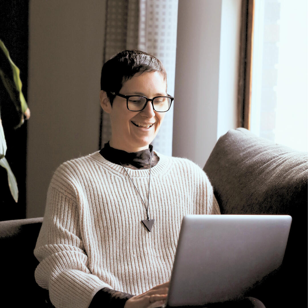 Living Yesfully Jennilee smiling at the computer, on a virtual coaching meeting